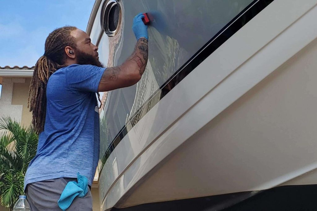 man putting ceramic coating on the yacht sarasota