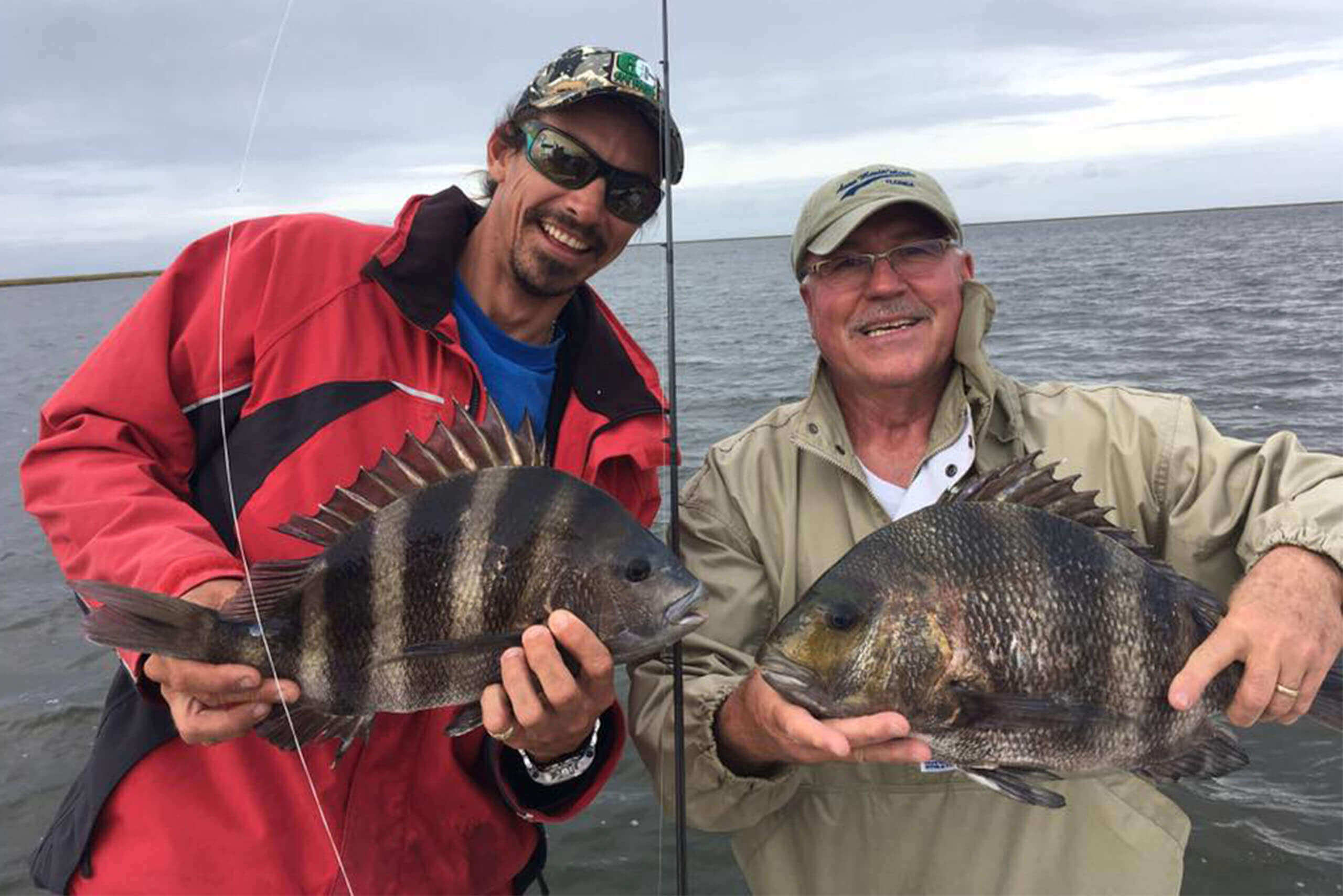 men smiling holding a big fish boat charter services 2